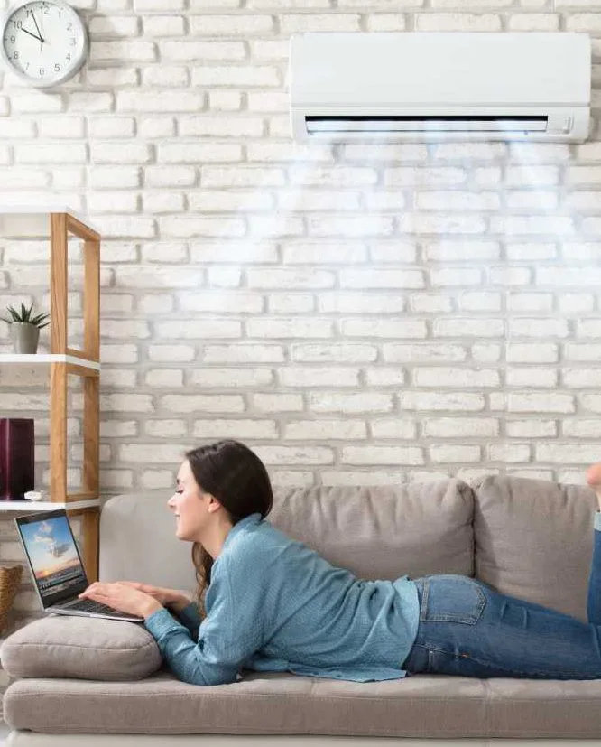 Woman laying on a couch using a laptop