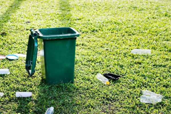 Plastic bottles on the ground near a trash can