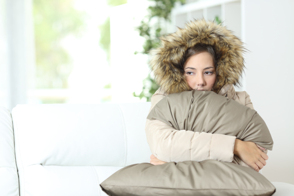 Woman in winter coat hugging a pillow