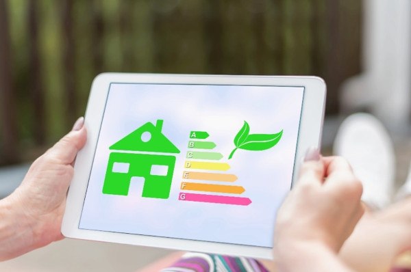 A person holding a tablet with a picture of a homes energy efficiency