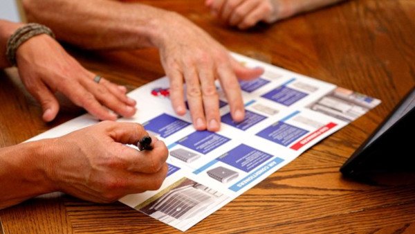 Sales professional showing a homeowner an equipment brochure