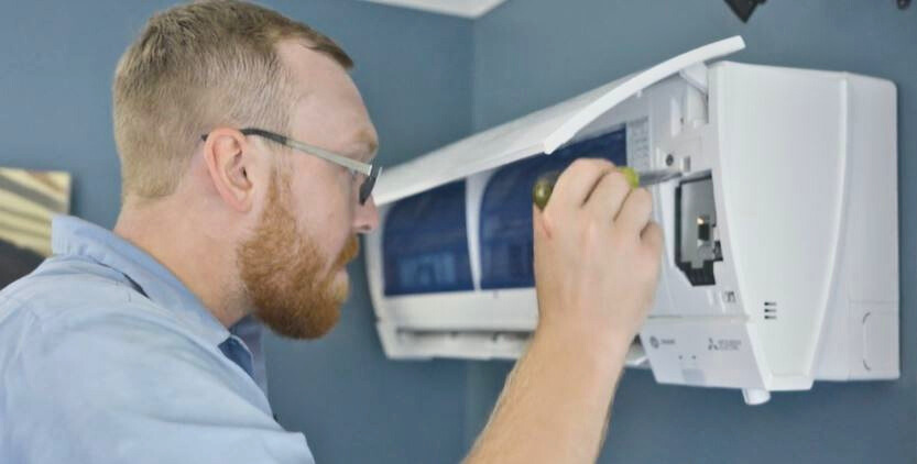 Man looking in a ductless HVAC system