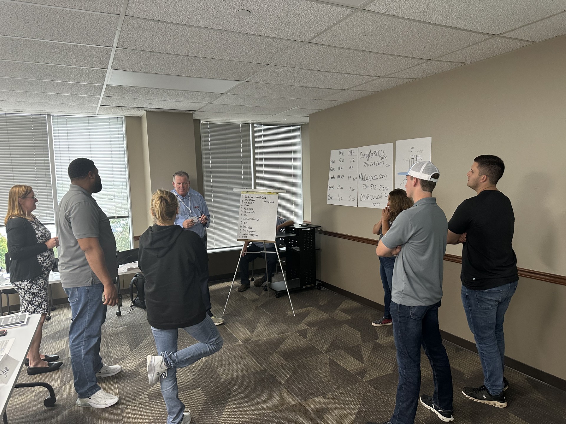  Fire & Ice team members participate in a duct design training session led by an instructor with a whiteboard.